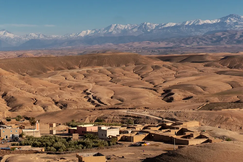 Desert hills and villages below the snowy High Atlas