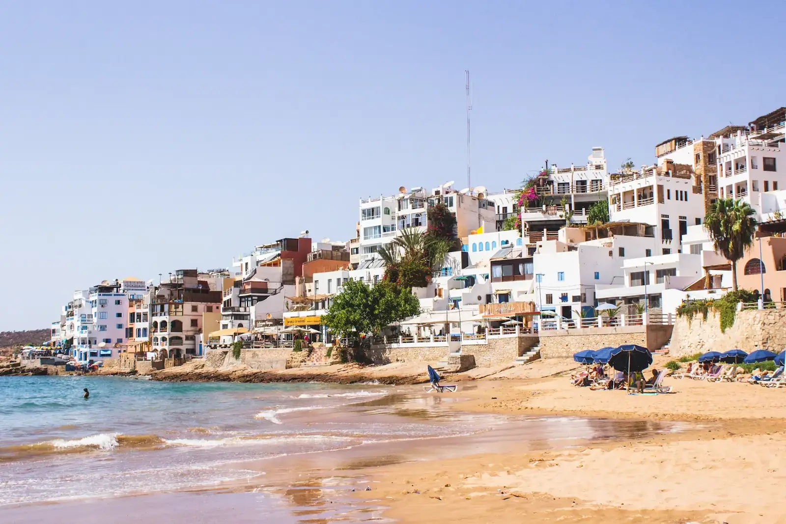 The white and colourful houses of Taghazout above its sandy beach