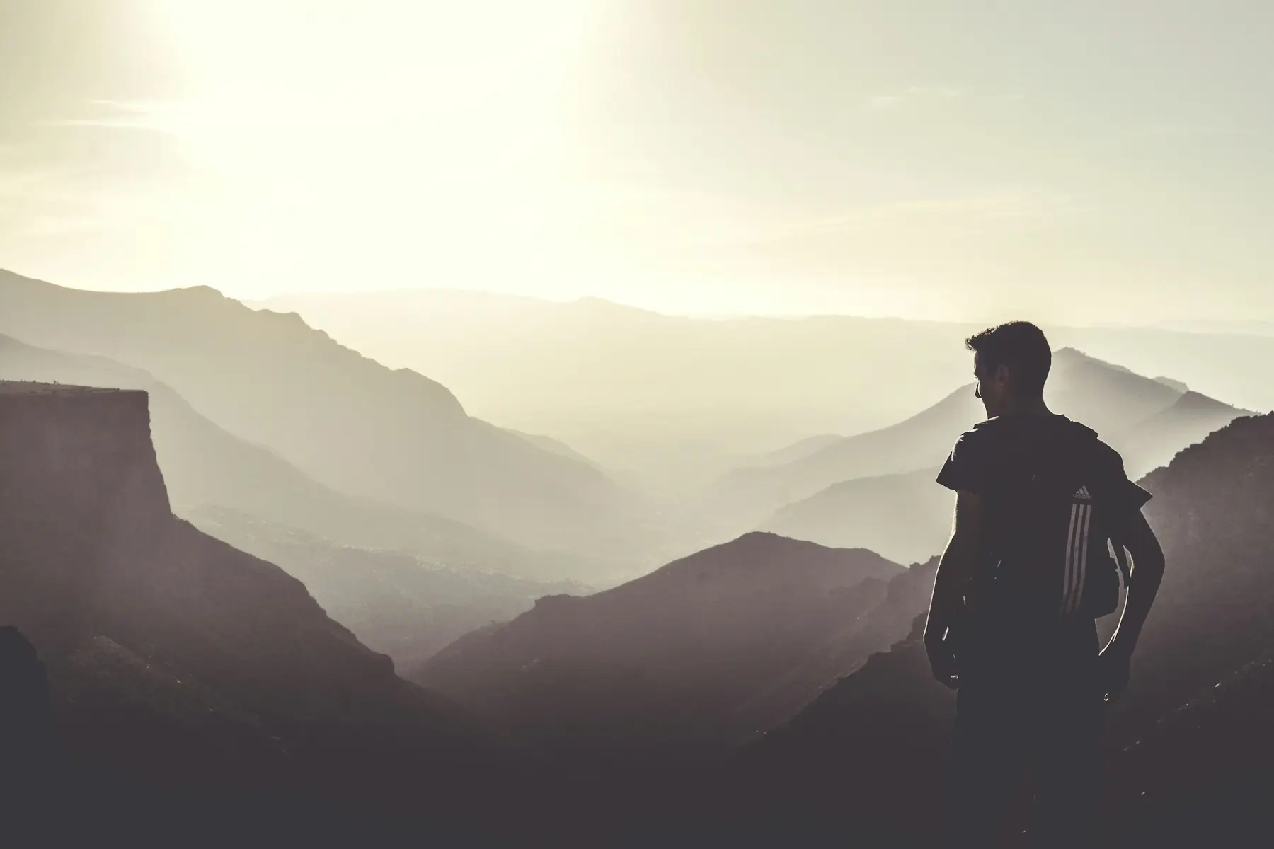 A hiker looking out over the hazy peaks of the Anti-Atlas near Tafraoute