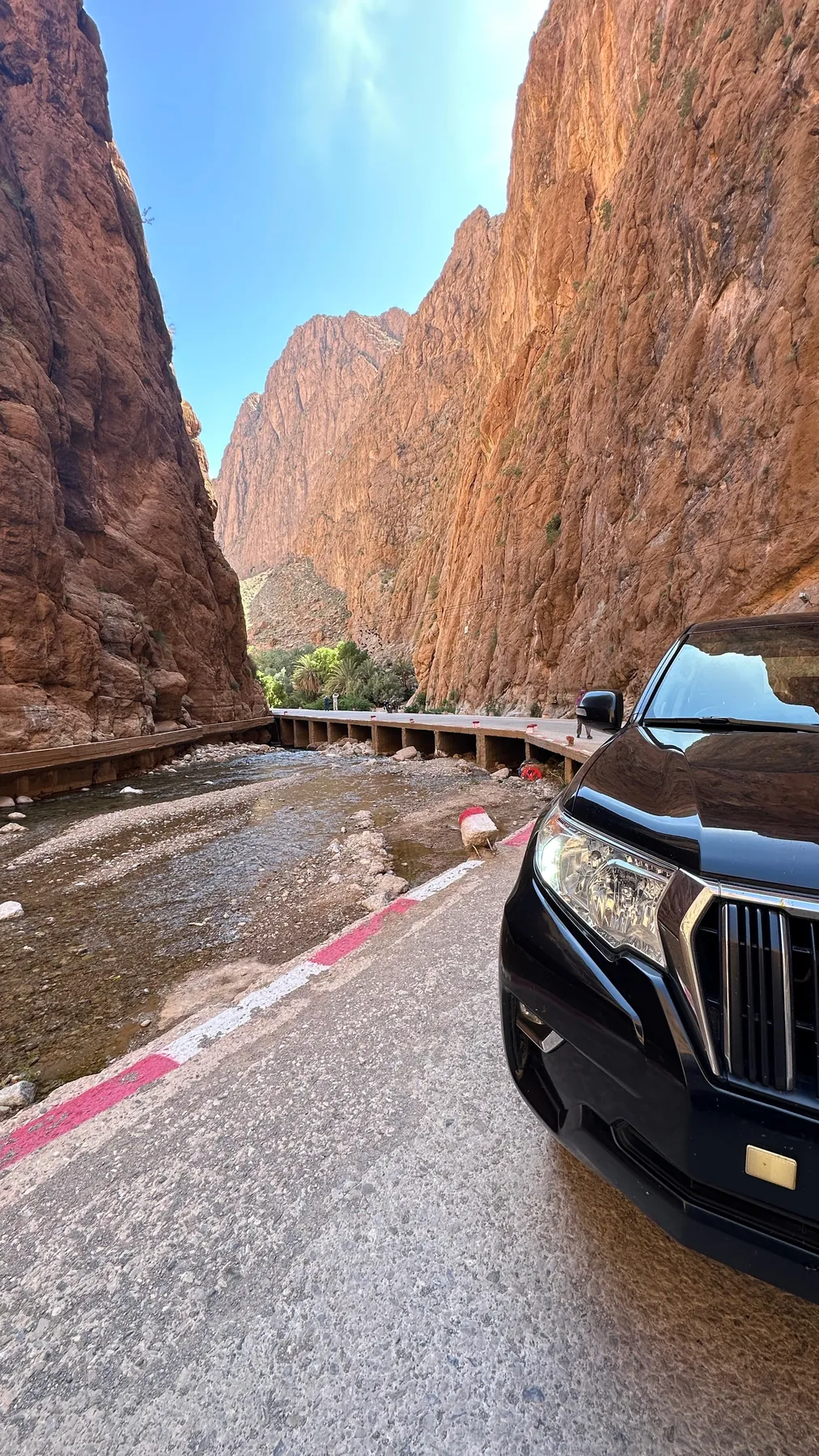 Our 4x4 on the road through the high red walls of the Todra Gorge